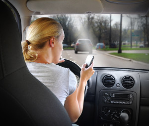 Woman Texting On Phone And Driving Car